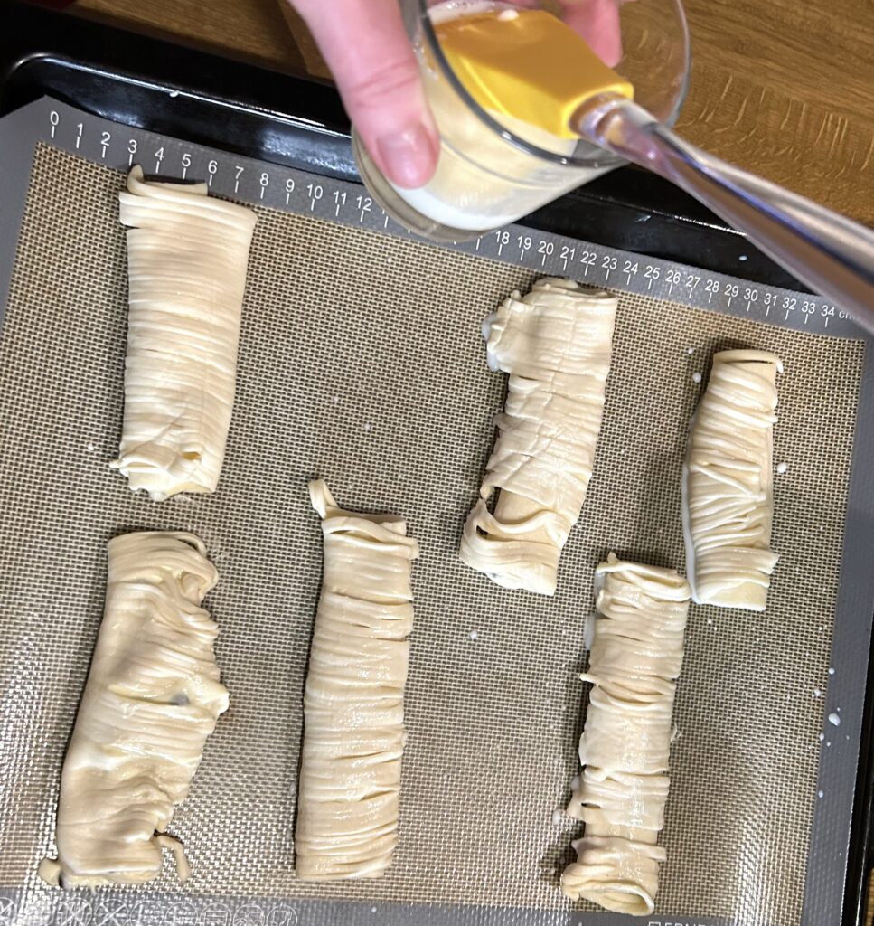 Brush the cannoli with milk and then sprinkle some sugar 