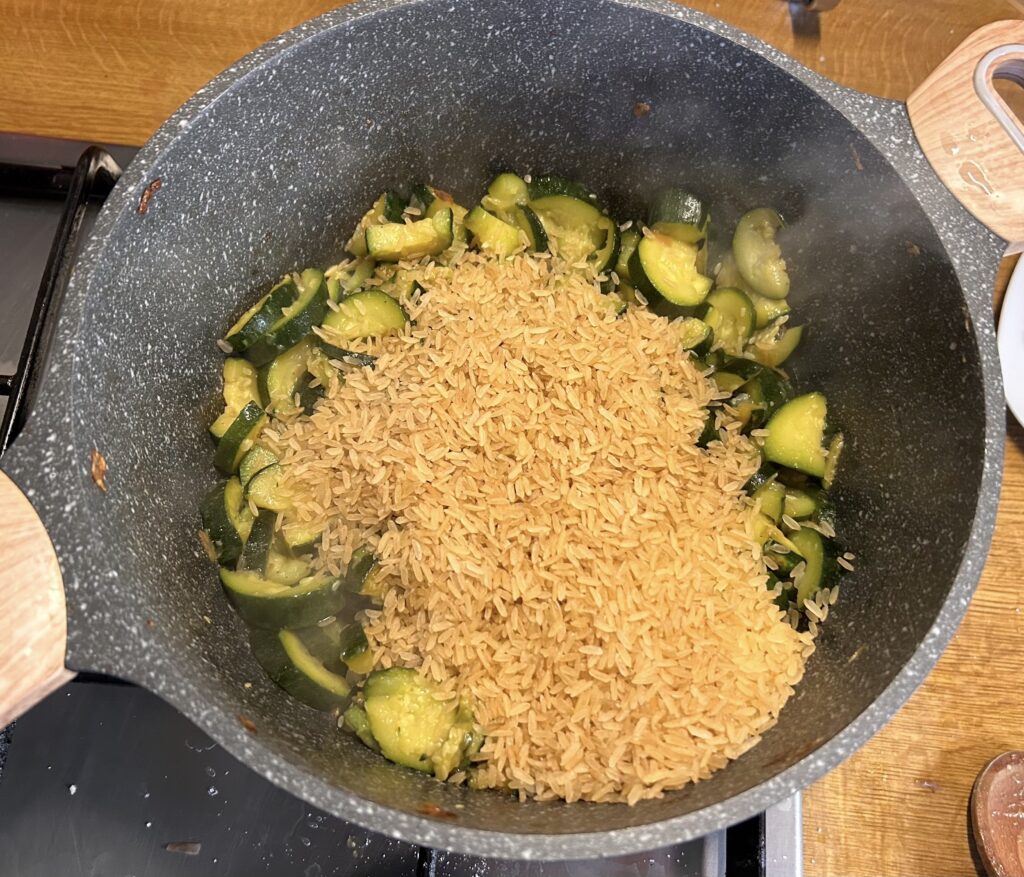 add the rice over the courgettes